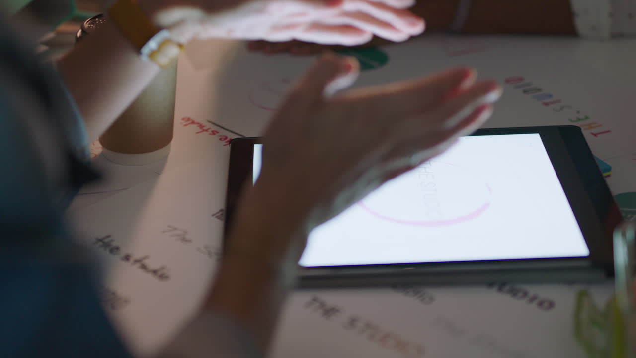 manos cercanas gente de negocios creativa trabajando hasta tarde equipo de marketing diseñando el logotipo de la compañía usando la pantalla de la tableta tormenta de ideas planeando el proyecto fecha límite en la oficina por la noche