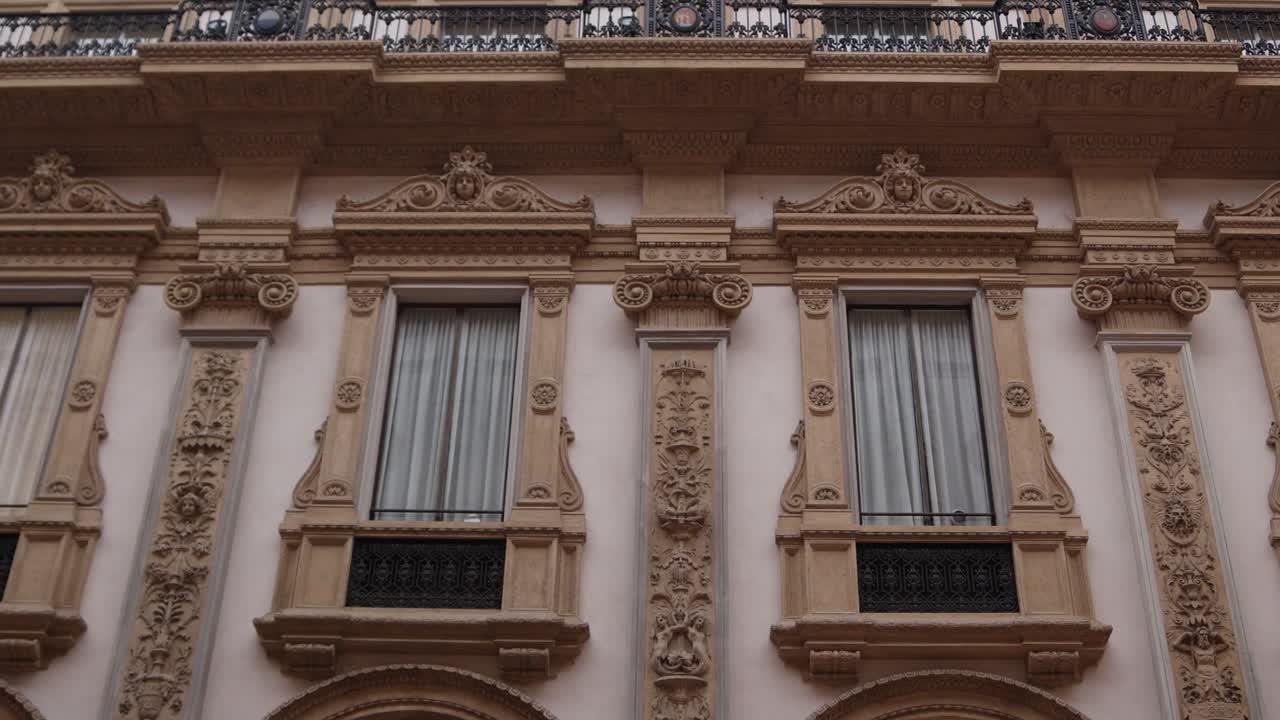 Facciata ornata di edificio classico con finestre e balcone.