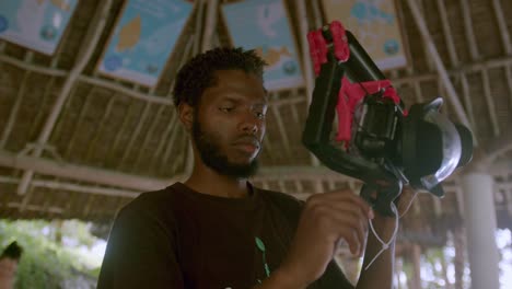 african man setting up underwater video camera for scuba diving