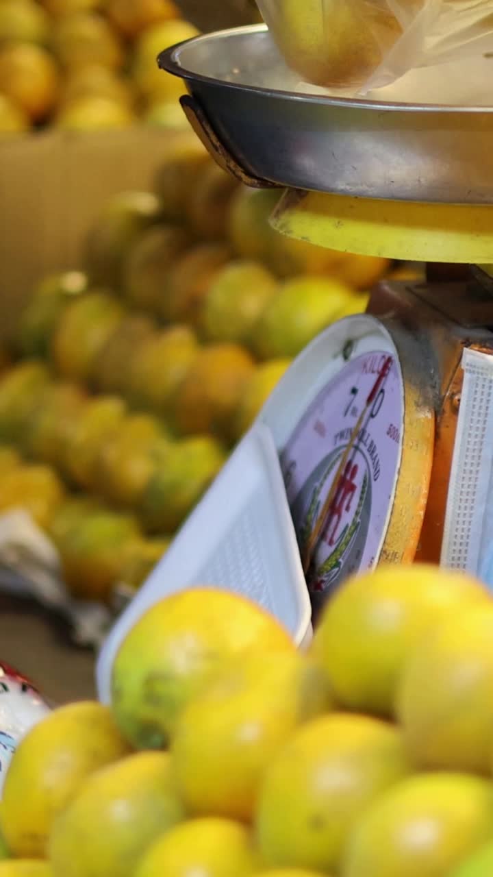 손으로 오렌지를 플라스틱 가방에 넣는 사람