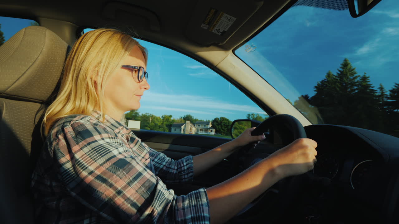 vista trasera de una mujer de mediana edad conduciendo un automóvil en los suburbios de los estados unidos