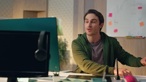 friendly creator greeting computer videocall at office. smiling guy waving hand
