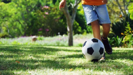 Boy-playing-football-in-park-4k