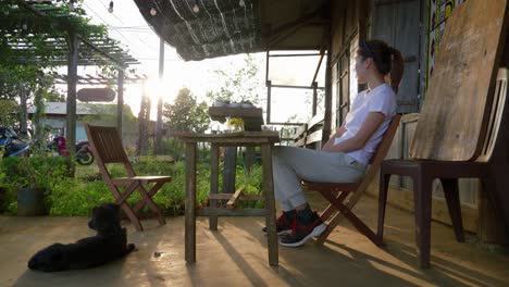 asian woman sitting outdoors with a dog while drinking from a glass, daytime, vietnam