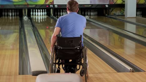 dos jóvenes discapacitados en sillas de ruedas jugando al bolos en el club