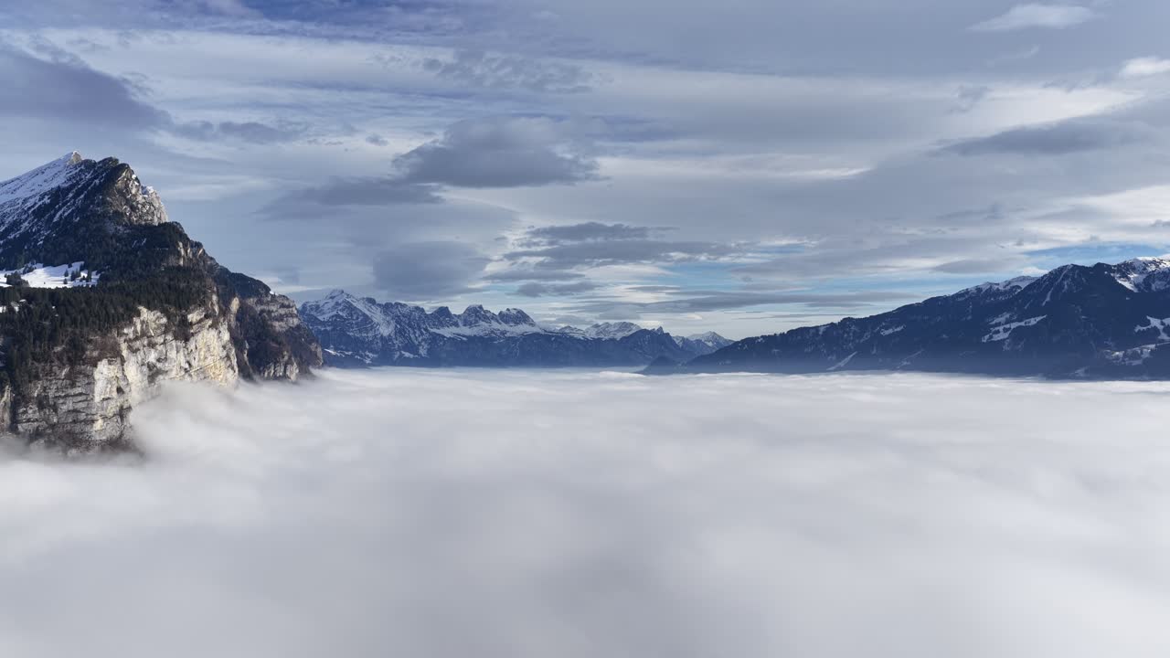 드넓게 펼쳐진 구름 바다를 마주하고 솟아 있는 높은 절벽과 알프스 산맥