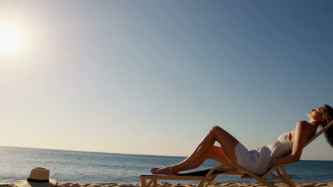 woman relaxing on beach chair by the ocean