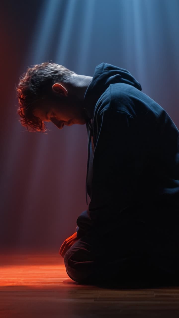 A Contemplative Moment: A Dramatic Lighting Scene with a Young Man in a Hoodie, Captured in Two Frames Reflecting Isolation and Introspection