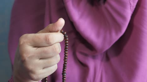 woman praying with prayer beads