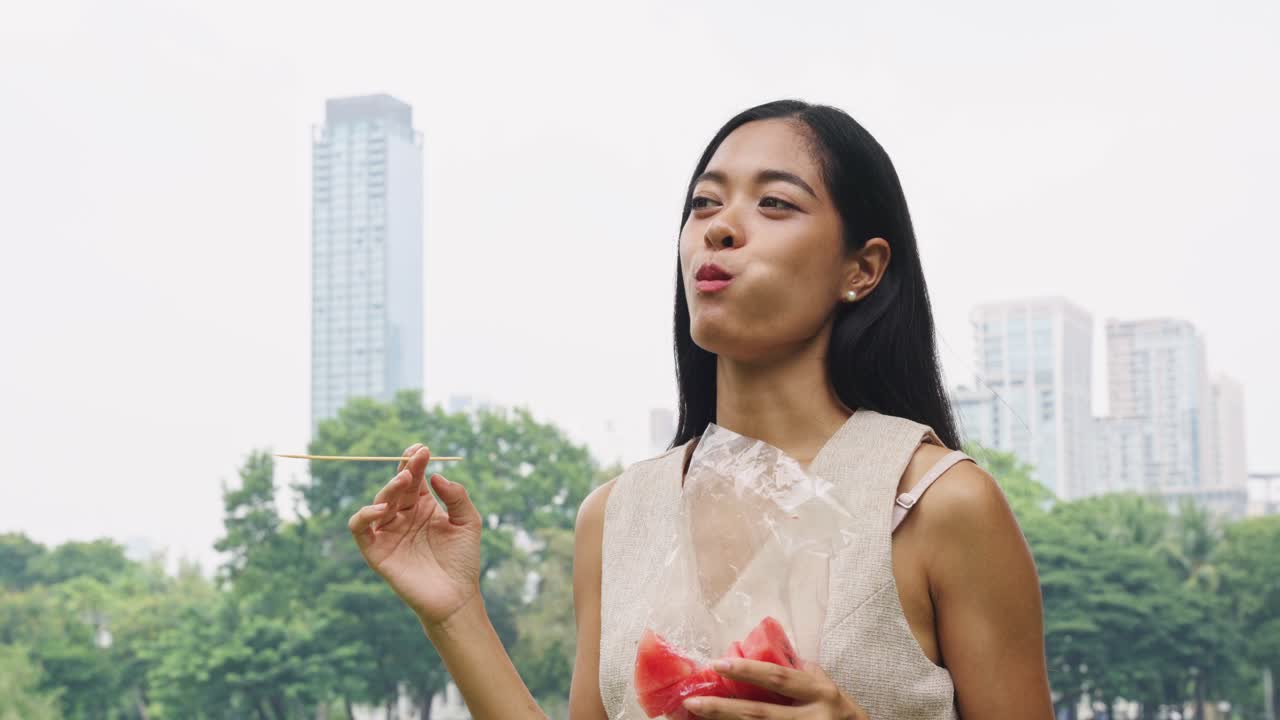 Woman eating watermelon in a park