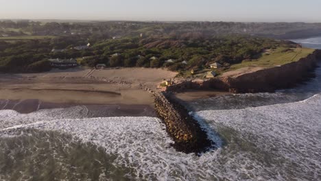 Imágenes-Aéreas-De-Drones-De-La-Hermosa-Costa-Argentina-Con-Playa-De-Arena-Luna-Roja-Durante-La-Puesta-De-Sol-En-Chapadmalal,-Argentina