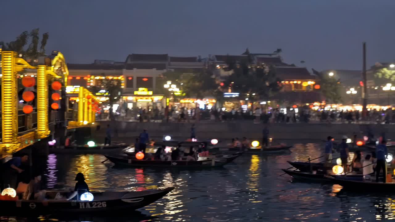 Tourists and visitors enjoy lantern boat rides and visit the lantern-bedecked bridge and stores around the scenic Thu Bon River in the Old Town section of Hoi An, Vietnam.