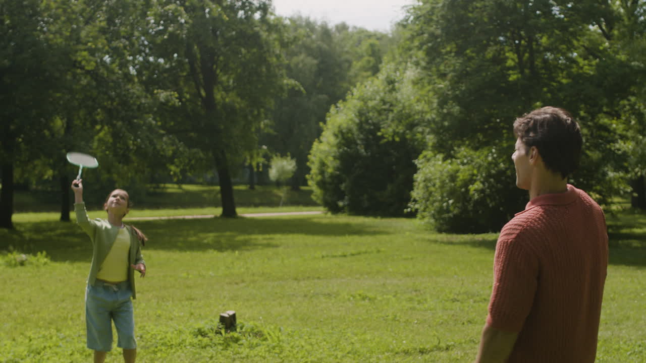 padre e hija jugando al bádminton en el parque