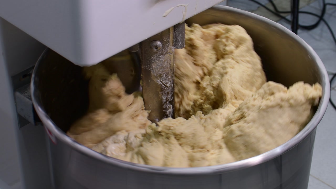 Fluffy dough mixing in an industrial mixer for baking