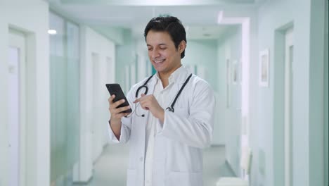 Happy-Indian-doctor-scrolling-through-phone