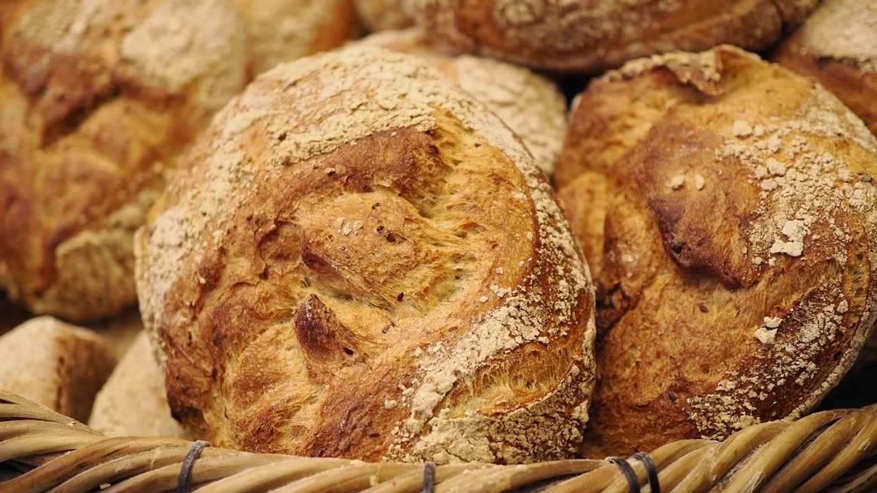 Pagnotte di pane a lievitazione naturale appena sfornate in un cesto di vimini