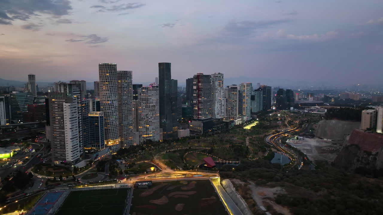 volando alrededor del iluminado parque la mexicana, colorida noche en santa fe, méxico - vista aérea