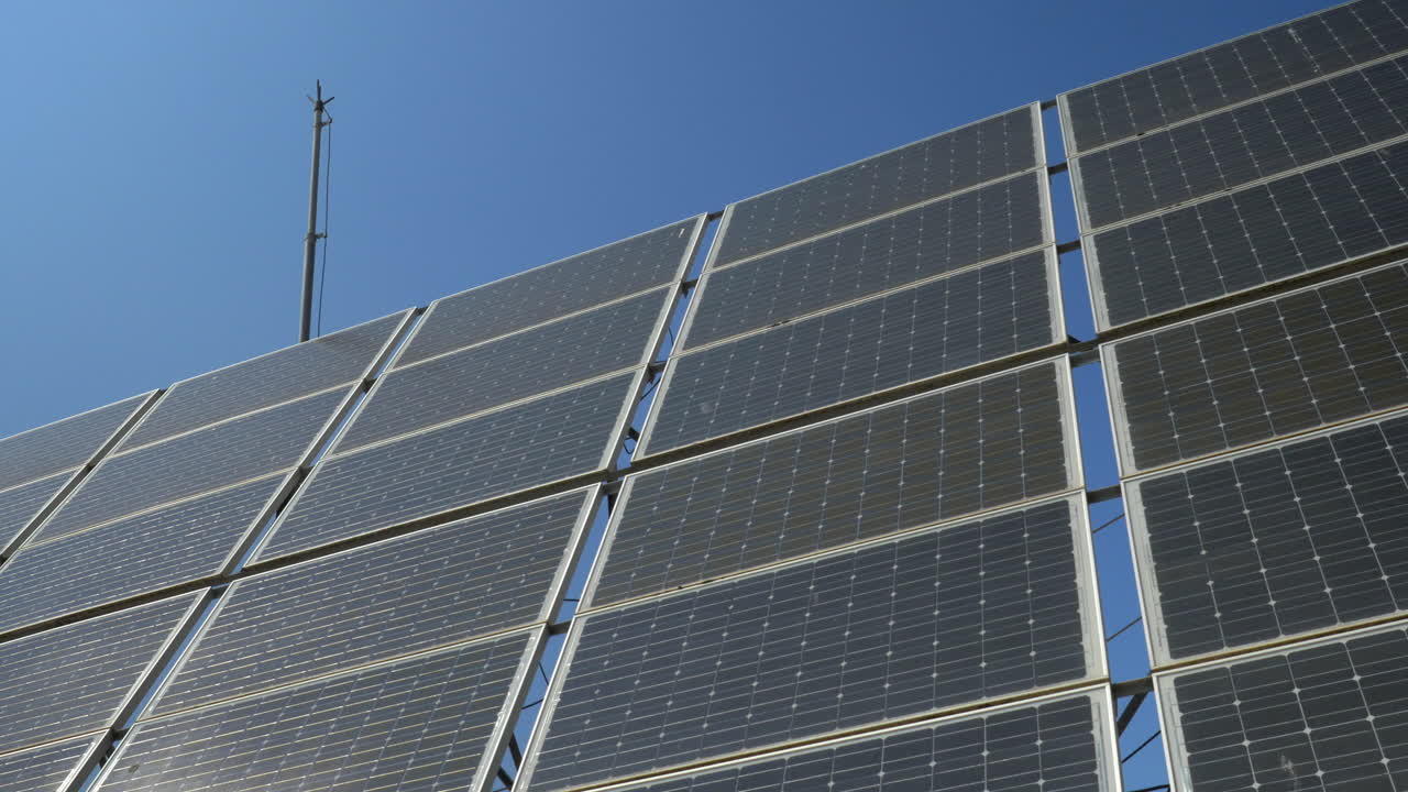 movimiento de la toma del sol a los paneles solares contra el cielo claro azul