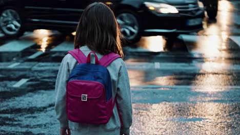 child crossing the street in the rain