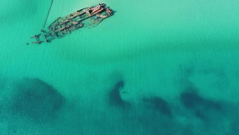 aerial shot by drone of a shipwrecked ship very close to a beach in epanomi,thessaloniki with blue water in greece