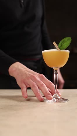 bartender preparing an orange cocktail