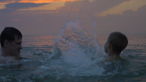 Bei-Sonnenuntergang-Schwimmen-Vater-Und-Sohn-Im-Meer-Der-Stadt-Perea-In-Griechenland