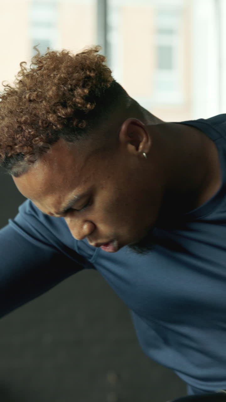 Young Man Exercising on Stationary Bike in Gym