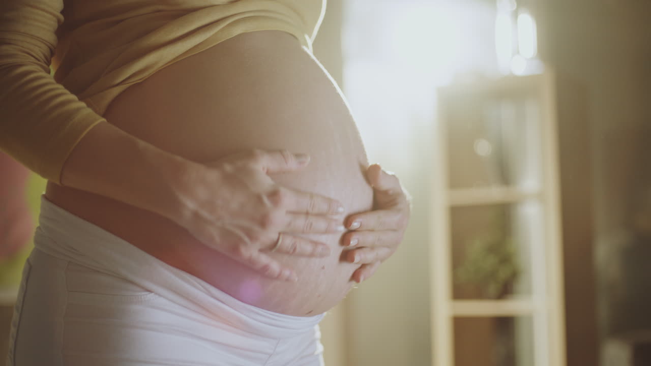 임신 한 여자는 그녀의 아랫 배를 만지고