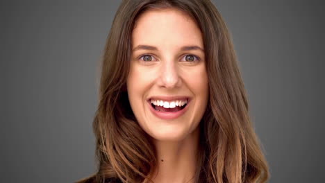 Surprised-woman-smiling-on-grey-background