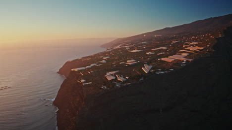 aerial drone shot over high coastline at sunset in la palma island, canary islands, spain.
view of the rugged volcanic cliffs and the vast ocean waves crushing on the rocks.