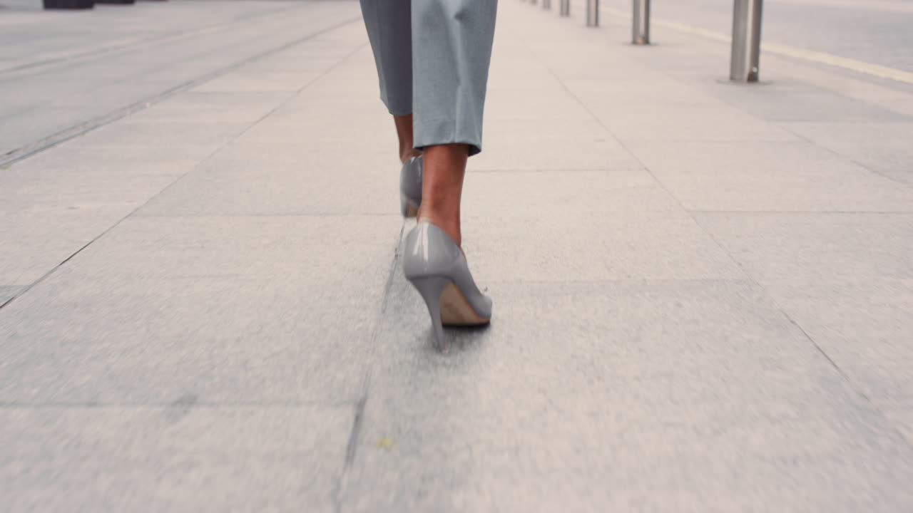 Beautiful mixed race business woman's feet walking through city