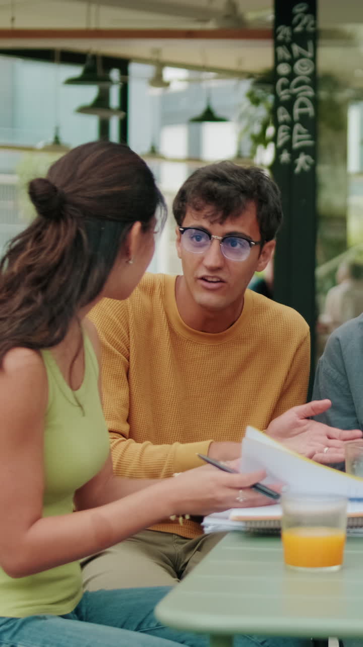 Close up of a diverse group of students having a lively conversation and using