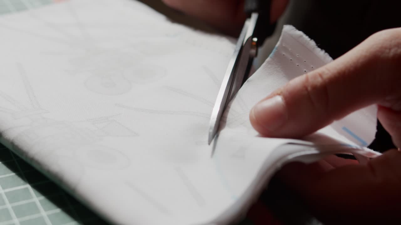 Scissors close up cutting fabric towards the camera.