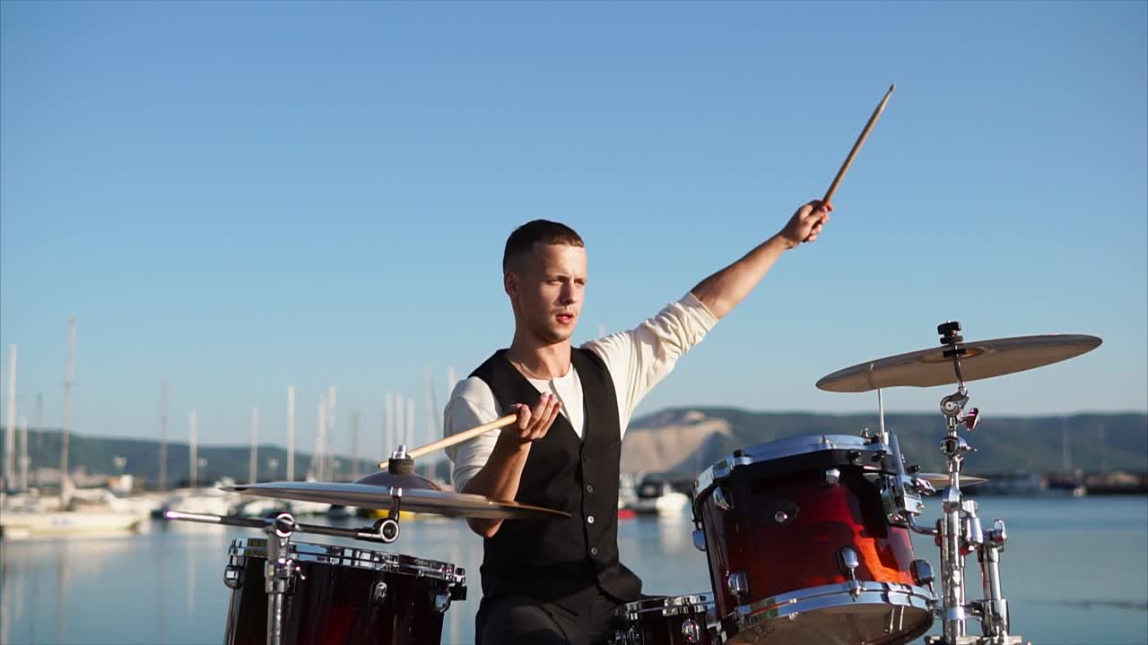 Drummer playing drums at a harbor