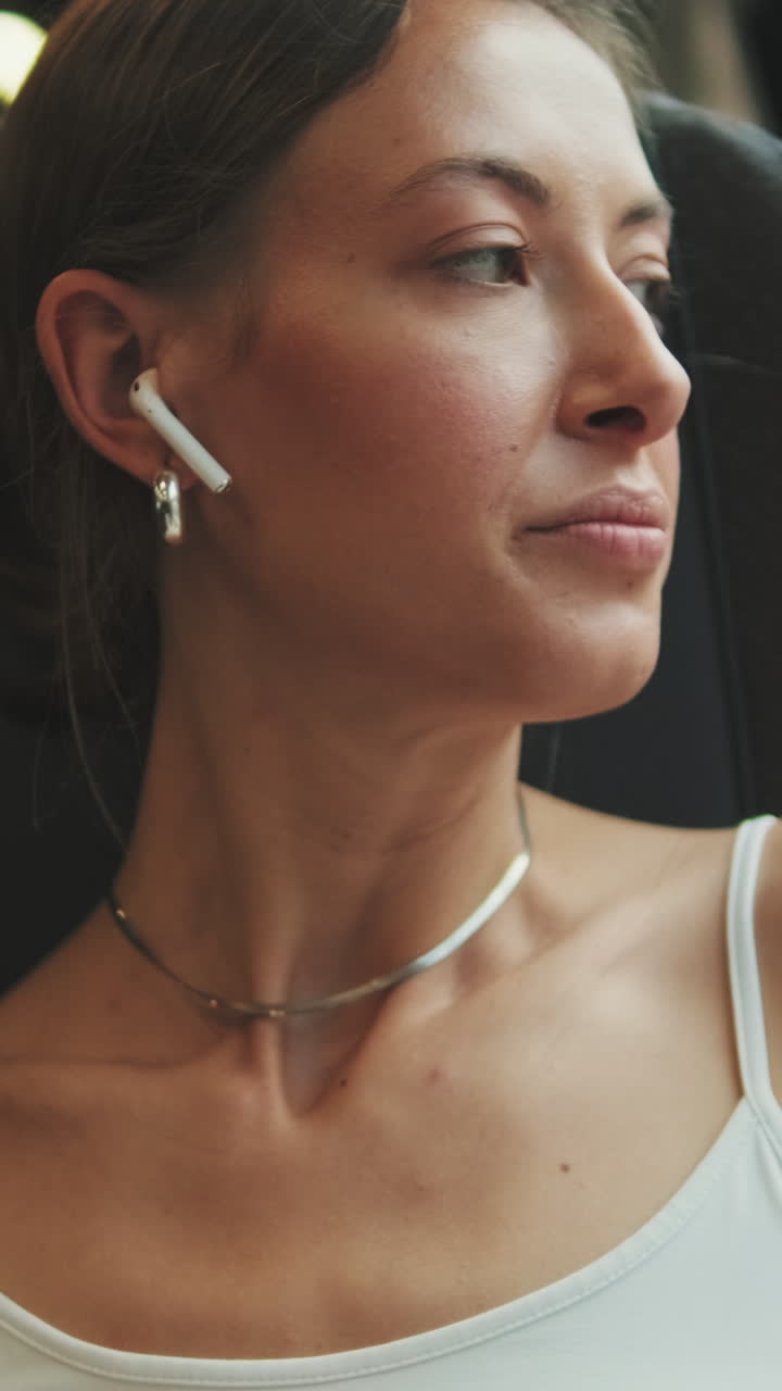 Giovane donna con auricolari wireless che usa lo smartphone
