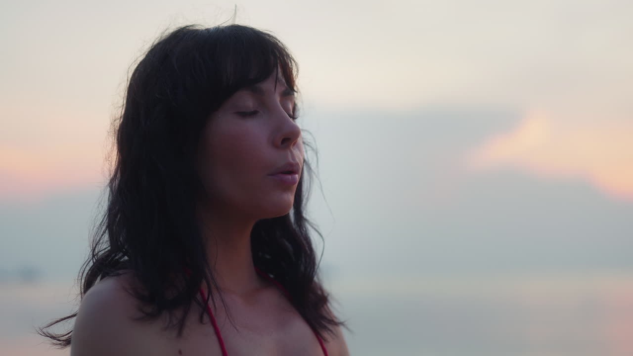 Close-up of Woman Meditating with Eyes Closed at Sunset