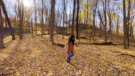 girl walking on a beautful forest during an autumn afternoon in minnesota yellow leaves on the ground