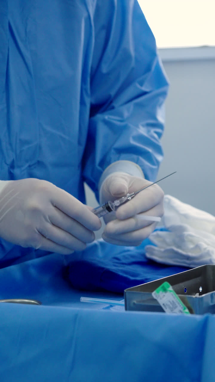 Doctor preparing a needle for administering anesthesia