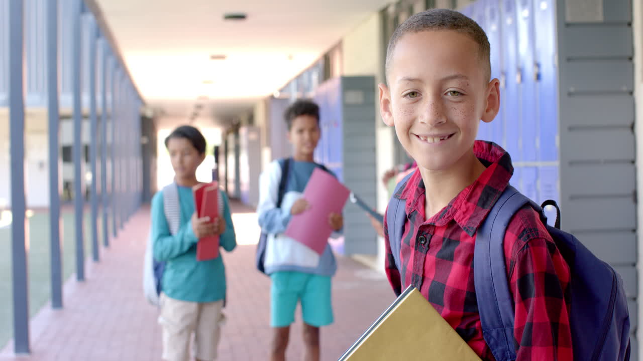 niños biraciales sonriendo en un pasillo de la escuela