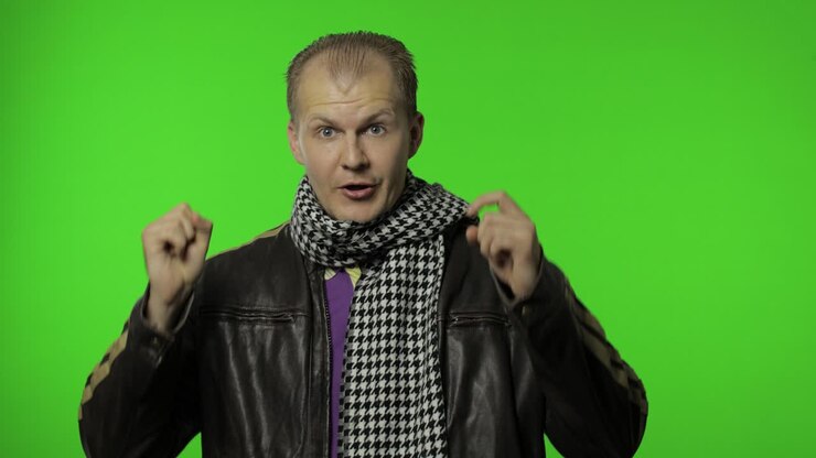 Handsome positive rocker man in brown denim jacket pointing finger at camera. Chroma key