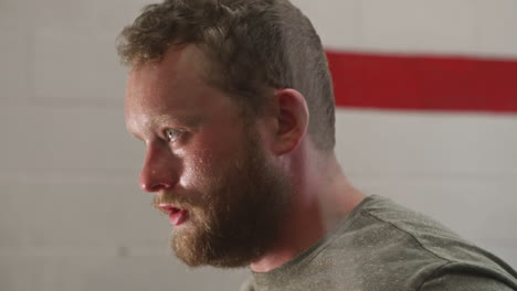 Man-sweating-heavily-with-determined-look-while-jumping-rope-indoors,-Close-Up,-Slide-Left,-Slow-Motion