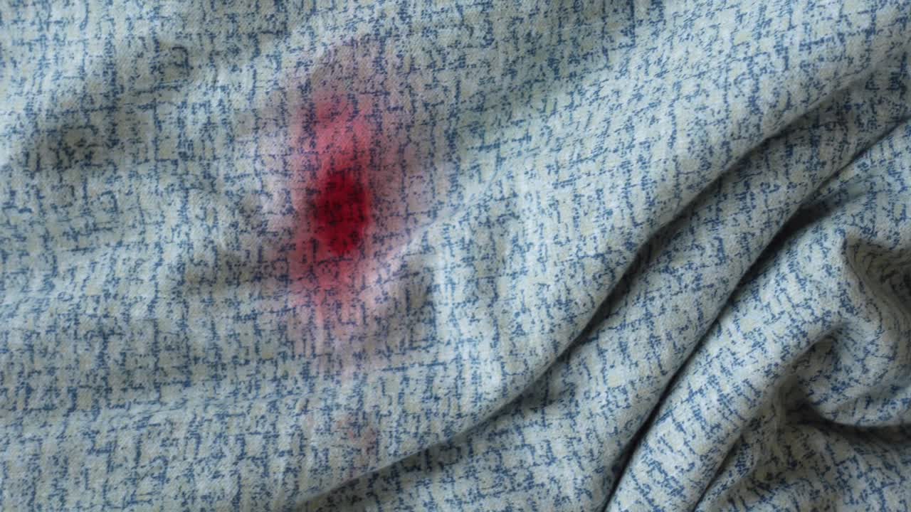 Red Stain on Light Blue Patterned Fabric