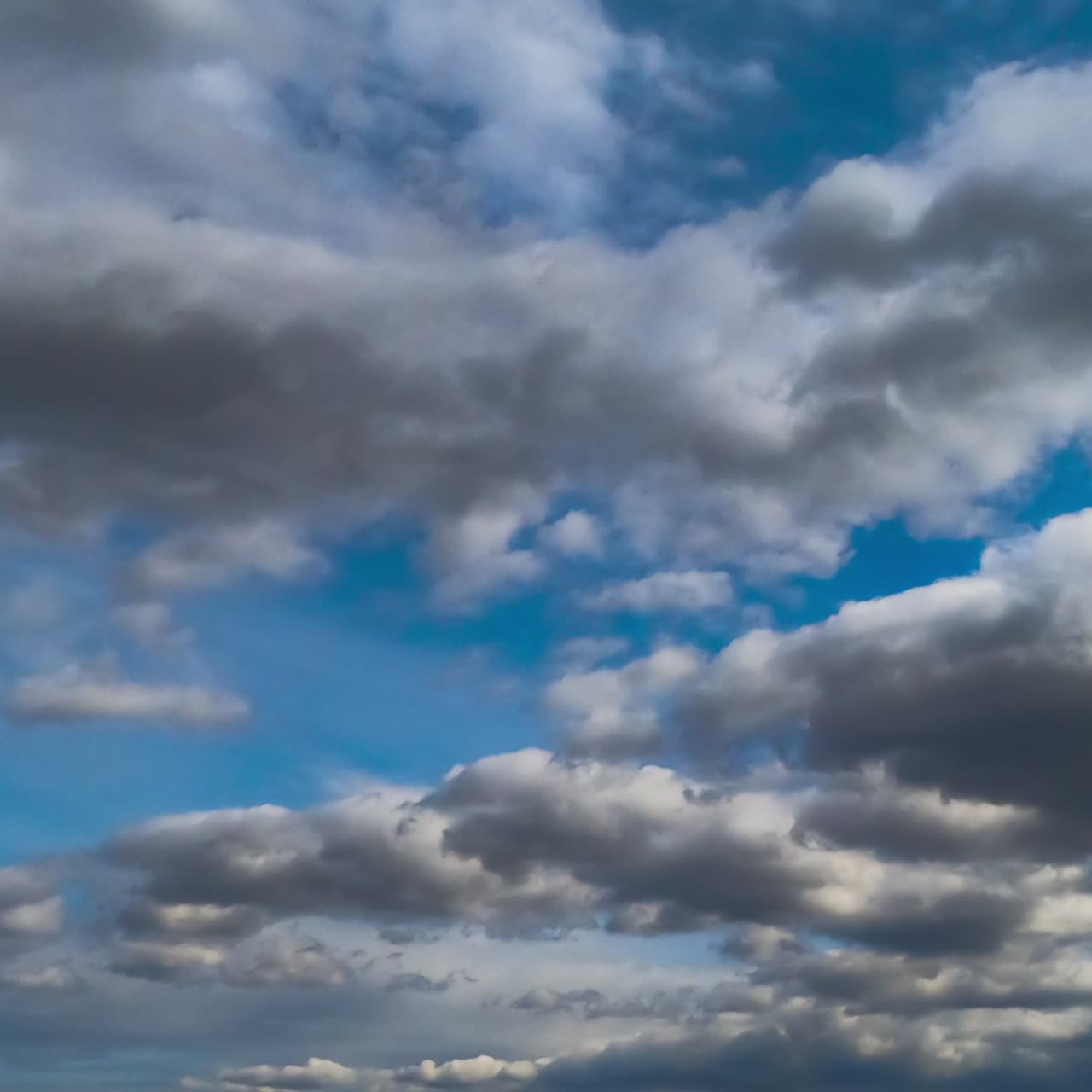 Light clouds transforming into heavy grey dramatic cloudscape. Low angle view. Timelapse