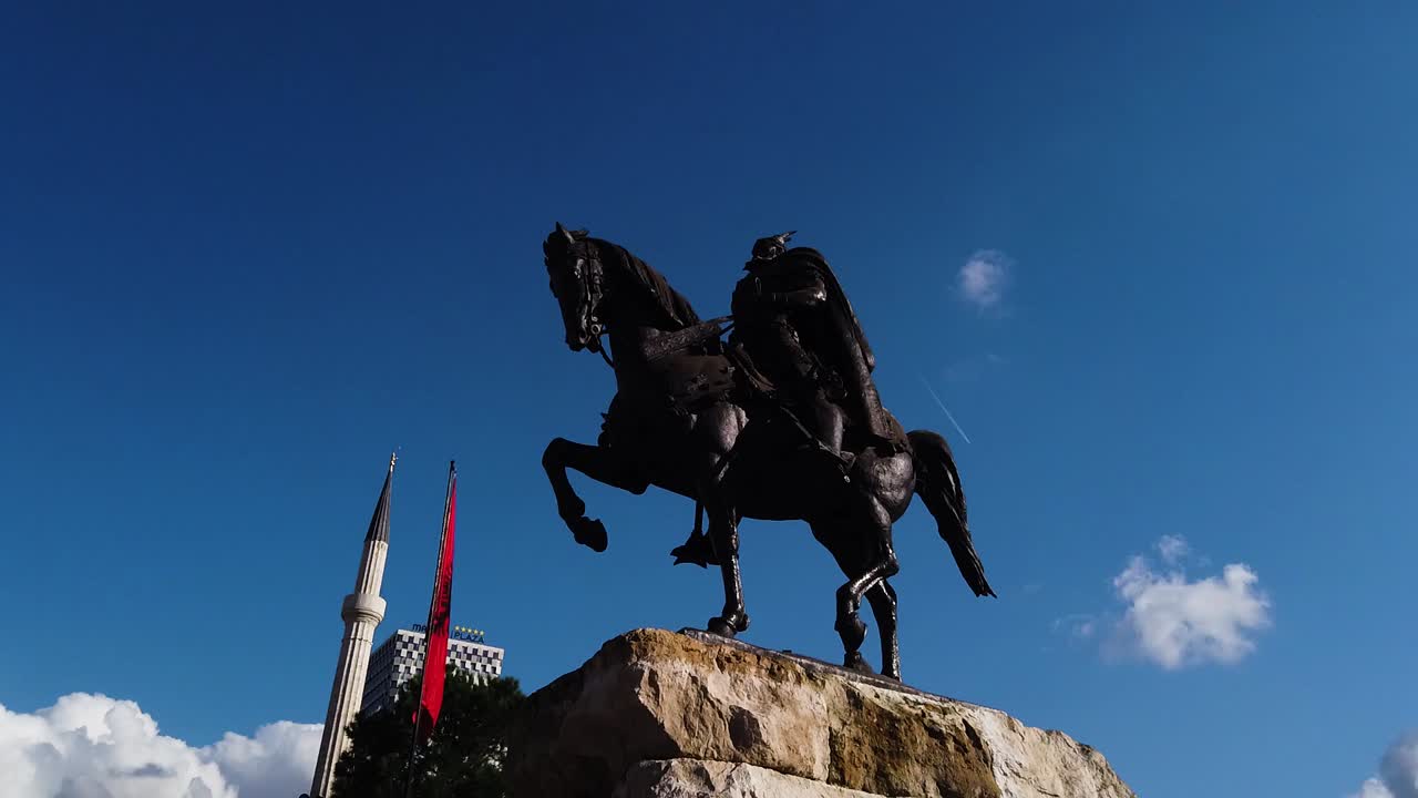 Silhouette of horseman on the horse riding. Statue of Sheshi Skenderbej in Tirana center. Motion Shot