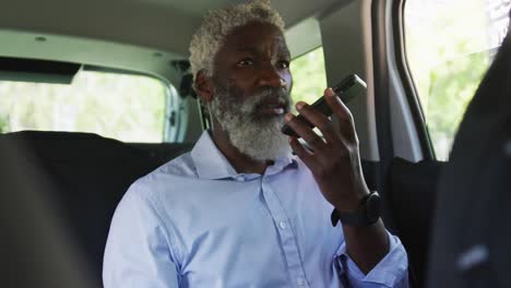 african american senior man talking on smartphone while sitting in the car