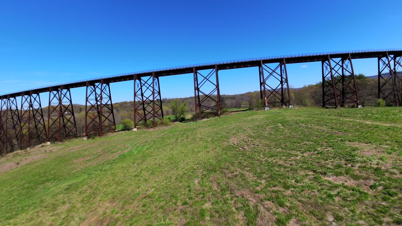 una vista aérea de bajo ángulo con un dron fpv volando bajo el viaducto moodna en salisbury mills, ny en un día soleado
