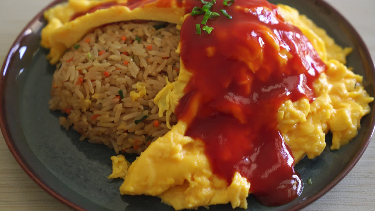 arroz frito aromatizado en una envoltura de tortilla o omurice al estilo japonés - estilo de comida asiática