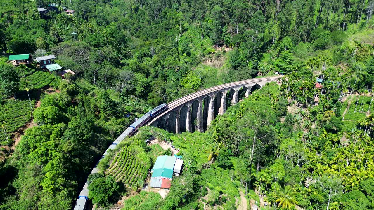 Aerial drone landscape view of train with carriage locomotive crossing Nine arch bridge landmark railway in scenic forest Ella Sri Lanka Asia travel transport
