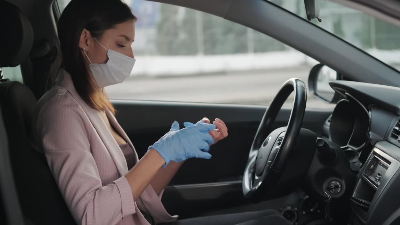 mujer con máscara y guantes en un coche