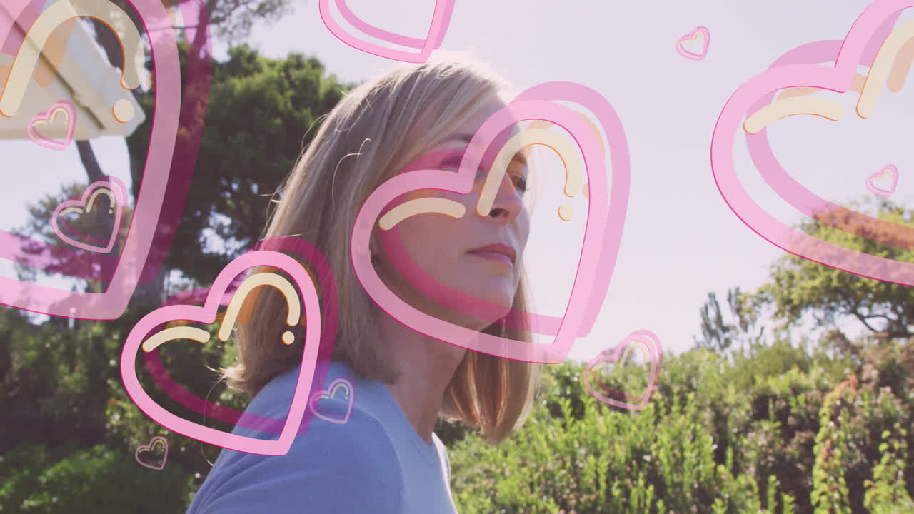 In sunny garden, woman surrounded by pink hearts animation outdoors